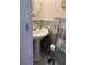 Small bathroom with pedestal sink and marble tile at 3218 Ramblewood N Dr # 19C2, Sarasota, FL 34237