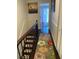Upstairs hallway featuring a floral rug and staircase at 3218 Ramblewood N Dr # 19C2, Sarasota, FL 34237