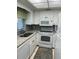 Bright kitchen features granite countertops and white appliances at 3751 S School Ave # 29, Sarasota, FL 34239