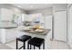 Bright kitchen featuring white cabinets, an island with bar seating, and tile flooring at 6205 Triple Tail Ct # 101, Lakewood Ranch, FL 34202