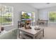 Bright and airy living room with modern decor and views of trees visible through large, bright windows at 6205 Triple Tail Ct # 101, Lakewood Ranch, FL 34202