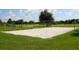 Sand volleyball court within a community park surrounded by lush greenery and trees at 6205 Triple Tail Ct # 101, Lakewood Ranch, FL 34202