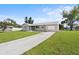Ranch style home with driveway and mature landscaping at 6352 Coniston Ter, North Port, FL 34287