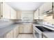 Traditional kitchen with white cabinets, tile countertops, and classic appliances at 6352 Coniston Ter, North Port, FL 34287