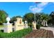 The Oaks Club entrance with lush landscaping and a guard house at 75 Osprey Point Dr, Osprey, FL 34229