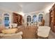 Bright living room featuring arched windows, built-in bookshelves, and comfortable seating at 75 Osprey Point Dr, Osprey, FL 34229