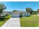 Single-Gathering home with gray exterior and paved driveway at 7648 Totem Ave, North Port, FL 34291