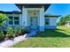 Front door entrance with gray door and paver walkway at 7648 Totem Ave, North Port, FL 34291