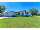 Single-Gathering home with gray exterior, paved driveway, and landscaping at 7648 Totem Ave, North Port, FL 34291