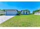 Single-Gathering home with gray exterior, paved driveway, and landscaping at 7648 Totem Ave, North Port, FL 34291