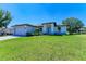 Single-Gathering home with gray exterior, paved driveway, and landscaping at 7648 Totem Ave, North Port, FL 34291