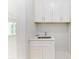 Laundry room with white cabinets and a utility sink at 7648 Totem Ave, North Port, FL 34291