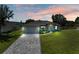 Single-Gathering home with gray exterior, paved driveway, and landscaping at dusk at 7648 Totem Ave, North Port, FL 34291