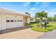 A two-car garage with a light beige exterior and lush landscaping at 117 Villa Dr # 117, Osprey, FL 34229