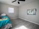 Cozy bedroom with teal bedding and wood-look floors at 1239 Groveland Ave, Venice, FL 34285