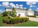 White two-story house with three-car garage, landscaping, and a paved driveway at 14538 Barefoot Ln, Parrish, FL 34219