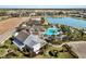 Aerial view of community pool, clubhouse, and lake at 14538 Barefoot Ln, Parrish, FL 34219