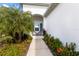 A walkway leads to a cozy sitting area on the front porch, surrounded by lush tropical plants at 14538 Barefoot Ln, Parrish, FL 34219