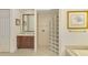 Bathroom with glass block shower, vanity and access to bedroom at 1509 Raphis Royale Blvd, Englewood, FL 34223