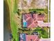 Bird's eye view of a house with pool and lush landscaping near a lake at 1509 Raphis Royale Blvd, Englewood, FL 34223