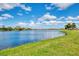 Tranquil lake view with green grass and distant homes at 1509 Raphis Royale Blvd, Englewood, FL 34223