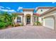 Mediterranean home with tile roof and paver driveway at 1509 Raphis Royale Blvd, Englewood, FL 34223