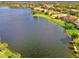Aerial view of a lakefront community showcasing a variety of homes and landscaping at 1509 Raphis Royale Blvd, Englewood, FL 34223