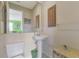 Small bathroom with pedestal sink and toilet at 1509 Raphis Royale Blvd, Englewood, FL 34223