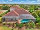 An aerial view of a home with a pool and a red tile roof at 1509 Raphis Royale Blvd, Englewood, FL 34223