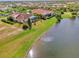 Aerial view of a home with a pool, lakefront location and lush landscaping at 1509 Raphis Royale Blvd, Englewood, FL 34223