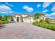 A beautiful two-story home with a three-car garage and a brick driveway at 1509 Raphis Royale Blvd, Englewood, FL 34223