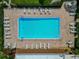 Aerial view of a large pool surrounded by lounge chairs, with palm trees and shade umbrellas at 1540 Glen Oaks E Dr # B336, Sarasota, FL 34232