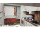 The kitchen features a colorful mural, white cabinets and vintage appliances at 1540 Glen Oaks E Dr # B336, Sarasota, FL 34232