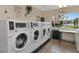 Laundry room with several washing machines and a bright window overlooking the pool at 1540 Glen Oaks E Dr # B336, Sarasota, FL 34232