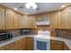 Kitchen with oak cabinets, tile backsplash, and modern appliances at 1640 Center Rd, Terra Ceia, FL 34250