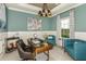 Elegant home office with wood desk, teal armchairs and statement lighting at 16435 Star Grass Cir, Bradenton, FL 34211