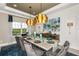 Formal dining room with a large table, statement lighting, and teal accents at 16435 Star Grass Cir, Bradenton, FL 34211