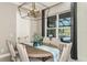 Bright dining room with a round table, modern chandelier and pool view at 16435 Star Grass Cir, Bradenton, FL 34211