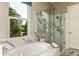 Spa-like bathroom with a soaking tub, glass-enclosed shower, and marble accents at 16435 Star Grass Cir, Bradenton, FL 34211