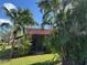 Rear view of condo with tile roof, palm trees, and lush landscaping at 3711 Pinecone Ct # 168, Sarasota, FL 34238