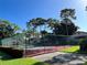 Tennis court with surrounding green landscape and trees at 3711 Pinecone Ct # 168, Sarasota, FL 34238