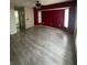 Large bedroom with wood-look floors and a red accent wall at 4016 Bula Ln, North Port, FL 34287