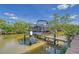 View of a boat lift on a canal, featuring a black pontoon boat, under a sunny blue sky at 467 Canal Rd # 467, Sarasota, FL 34242