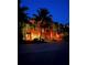 Stunning three-story townhome with palm trees and well-lit driveways in a tropical setting at dusk at 467 Canal Rd # 467, Sarasota, FL 34242
