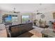 Bright living room featuring a dark leather sofa, ceiling fans, and a dining area with seating for four at 467 Canal Rd # 467, Sarasota, FL 34242