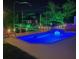 Backyard pool and boatlift illuminated at night, with a hot tub, deck, and outdoor seating at 467 Canal Rd # 467, Sarasota, FL 34242