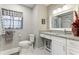 Well-lit bathroom featuring a granite vanity, framed mirror, and a toilet with coordinated gray and white accents at 4817 Sarasota Ave, Sarasota, FL 34234