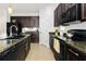 Modern kitchen with dark cabinetry, granite countertops, and stainless steel appliances at 8418 Nandina Dr, Sarasota, FL 34240