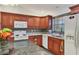 Modern kitchen with wood cabinets, granite countertops, and white appliances at 106 49Th E Ct, Palmetto, FL 34221