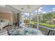 Screened porch with glass table and chairs, view of bedroom and garden at 1328 Siesta Bayside Dr # 1328-C, Sarasota, FL 34242